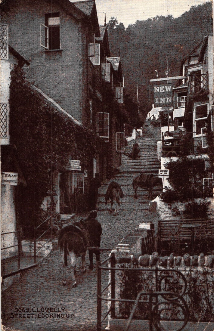 Postcard view of the steep cobblestone street with donkeys in Clovelly, Devon, England c. 1920s: Please view photos for further description and condition considerations. Please know the scans may be darker or lighter than the actual item's true appearance. ACME Auctions offers FREE DOMESTIC SHIPP
