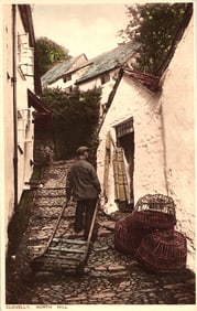 Postcard of a man pulling a sledge up the steep, cobbled North Hill in the village of Clovelly,