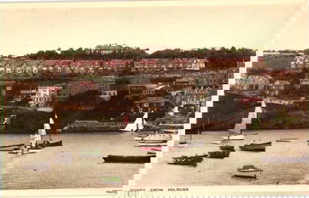 Postcard view of Fowey from Polruan, Cornwall showing homes on the hill and boats in the harbour.