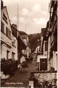 RPPC Real Photo Postcard of the steep cobblestone High Street in Clovelly, Devon with donkeys.