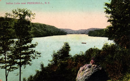 Postcard of a scenic view of Indian Lake near Peekskill, New York, with a figure on a rock c. 1910s