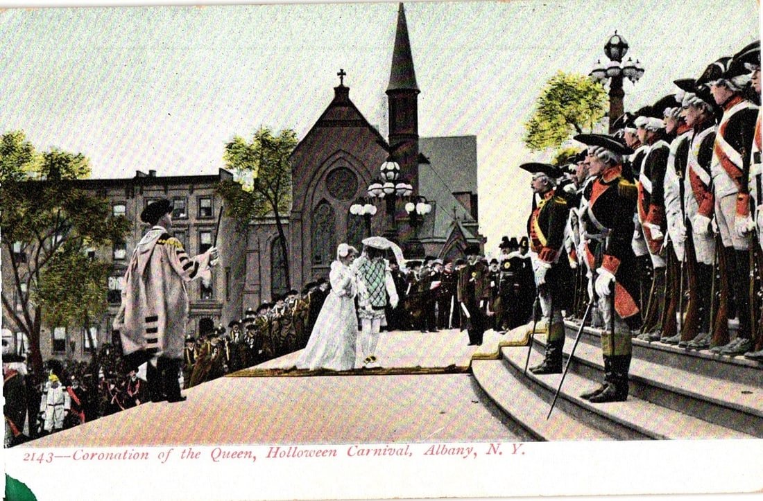 Holloween Carnival Queen Coronation, Albany, N.Y. Early 20th Century Chromolithograph Postcard: A ceremonial scene depicts a coronation event during a "Holloween Carnival" in Albany, N.Y. In the foreground, two central figures, a "queen" in a white gown and veil and a partner in white formal wea