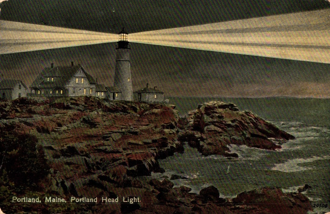 Portland Head Light at night, Maine, United States, early 20th century color lithograph postcard: A color lithograph showcases Portland Head Light on a rocky promontory in Maine, emitting bright beams of light across a dark sky. Several ancillary buildings are visible on the rugged coastline. The 