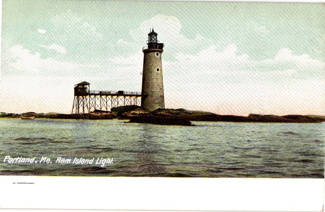 Ram Island Light, Portland, Maine Lighthouse with Wooden Bridge, Early 20th Century Postcard.: Ram Island Light, a cylindrical stone lighthouse topped with a lantern room, stands prominently on a rocky islet. An elevated wooden structure, likely a walkway or boathouse, connects to the lighthous