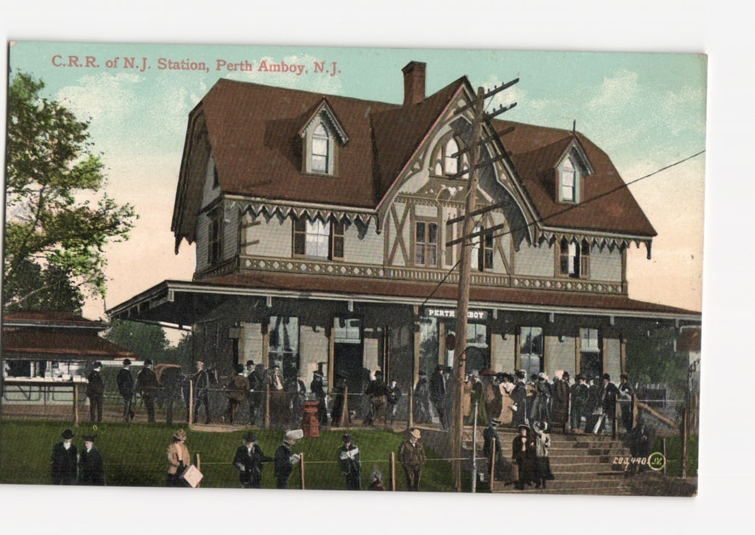 C.R.R. of N.J. Station, Perth Amboy, N.J. Train Depot with People, Early 20th Century Postcard: A large, ornate Victorian-style train station building, depicted as a chromolithograph or colorized illustration. The station features a multi-gabled roof, decorative shingle siding, and numerous dorm