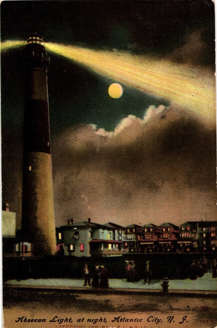 Scenic postcard: Absecon Light at night with moon and city buildings in Atlantic City, N. J., c.: A chromolithograph depicting the Absecon Lighthouse at night, emitting a strong beam of light across a dark sky. A full moon is visible through scattered clouds. The tall lighthouse, with distinct dar