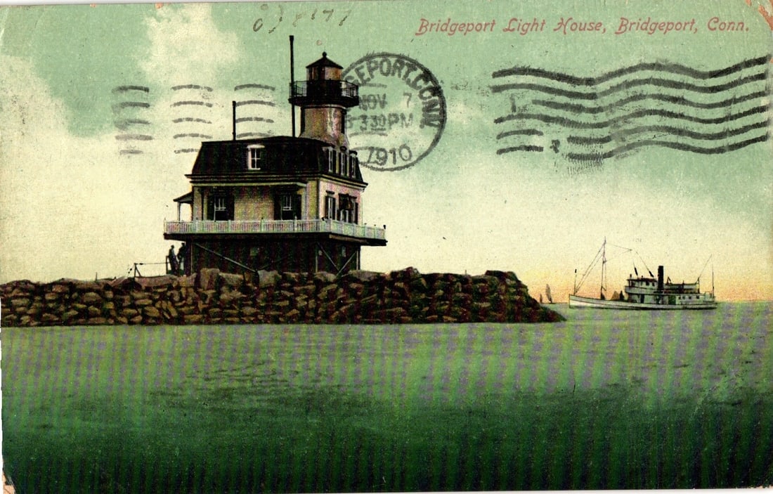 Historic Bridgeport Light House, Bridgeport, Conn., c. 1910 colorized photograph postcard: The Bridgeport Light House, a multi-story structure with a house-like base and a cylindrical tower featuring a lantern room, stands prominently on a rocky foundation in the water. A white railing enci