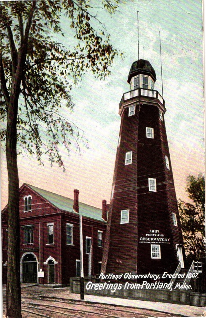 View of Portland Observatory, a 1807 structure in Maine, from an early 20th century postcard.: A color-tinted photographic reproduction, likely a chromolithograph, presents the Portland Observatory, a tall, tapering octagonal wooden tower. A two-story red building stands to its left, with a lar