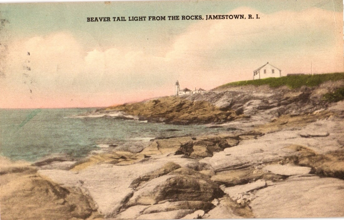 Beaver Tail Light from the Rocks, Jamestown, Rhode Island, 1942 hand-colored scenic postcard.: A panoramic view of Beaver Tail Light, Jamestown, Rhode Island, seen from a rocky shoreline. The foreground features large, irregular rock formations sloping down to the ocean on the left, where waves