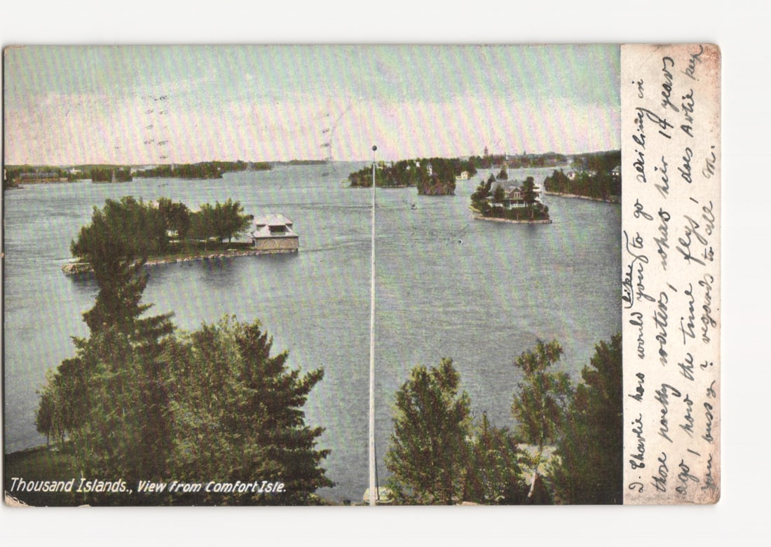 Scenic Photochrome Postcard of Thousand Islands with Buildings, View from Comfort Isle, 1908: A wide-angle photochrome view depicts numerous small, tree-covered islands dotting a broad expanse of water. Several islands feature discernible structures, suggesting residences or lodges. A tall, sl
