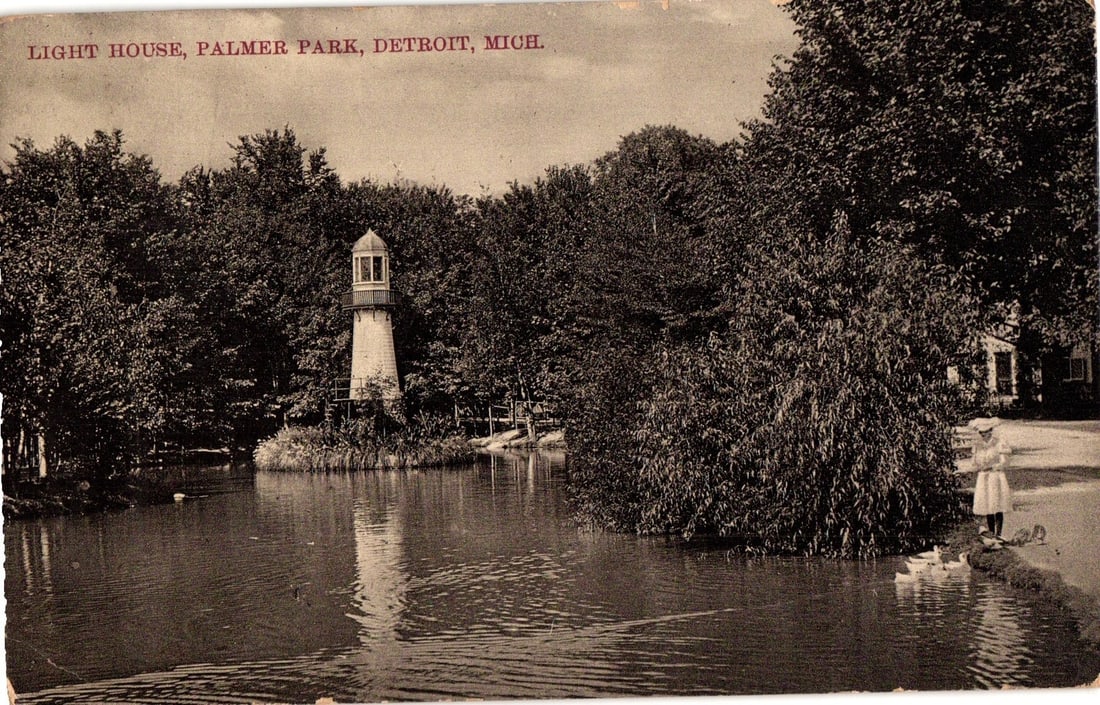 Vintage postcard featuring the Lighthouse at Palmer Park, Detroit, Michigan, with child and ducks.: A picturesque scene depicts a lighthouse situated on a small, treed island in a tranquil body of water. Dense foliage surrounds the water and the lighthouse structure, which features a white tower top