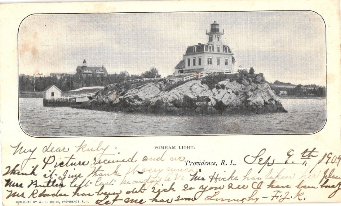Pomham Light Station, Providence, Rhode Island, circa 1904, historic United States postcard.: A detailed view of Pomham Light, a multi-story building with a light tower, situated on a rocky island in a body of water. A smaller ancillary structure connects to the light station via a walkway. An