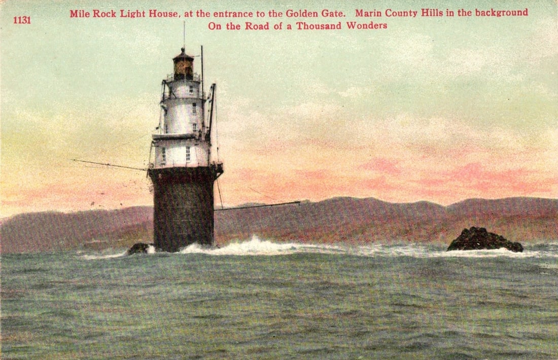 Historic Mile Rock Lighthouse at Golden Gate entrance with Marin County Hills background postcard: The Mile Rock Light House stands prominently in the center, a multi-tiered white structure with dark details atop a dark, cylindrical base. Waves crash around the lighthouse, which is situated in the 