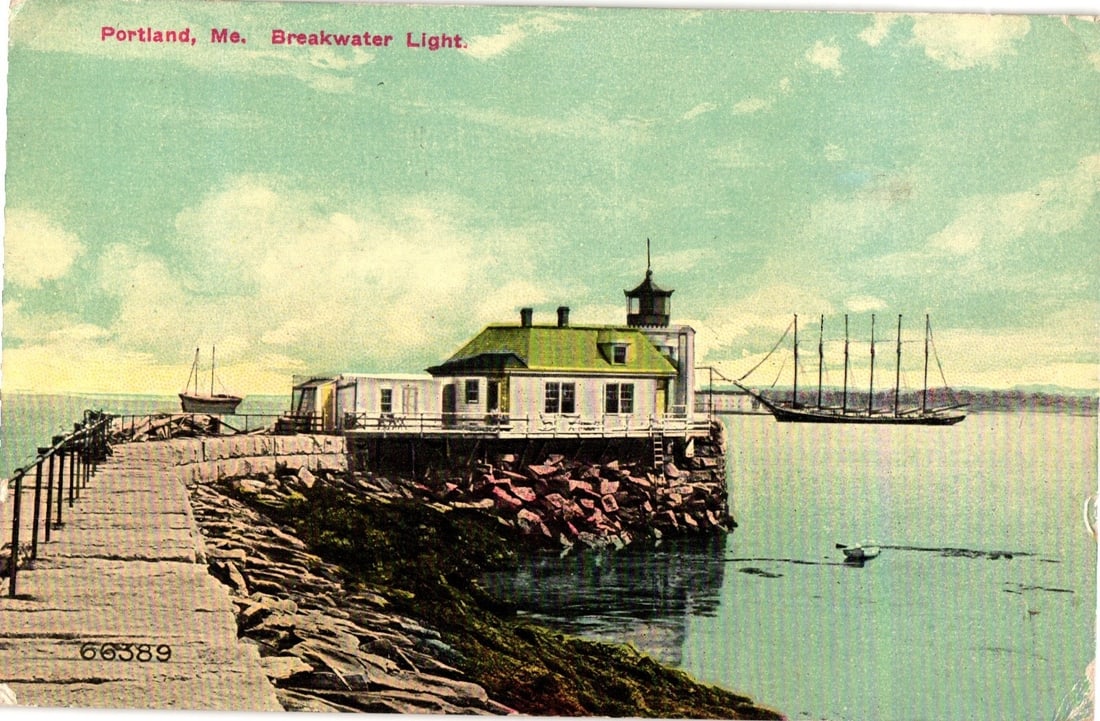 Portland, Maine Breakwater Light with Sailing Ship, Early 20th Century Chromolithograph Postcard: A chromolithograph postcard depicts the Portland Breakwater Light in Portland, Maine. The light station, a white building with a green roof and dark lantern room, is situated on a rocky outcropping at