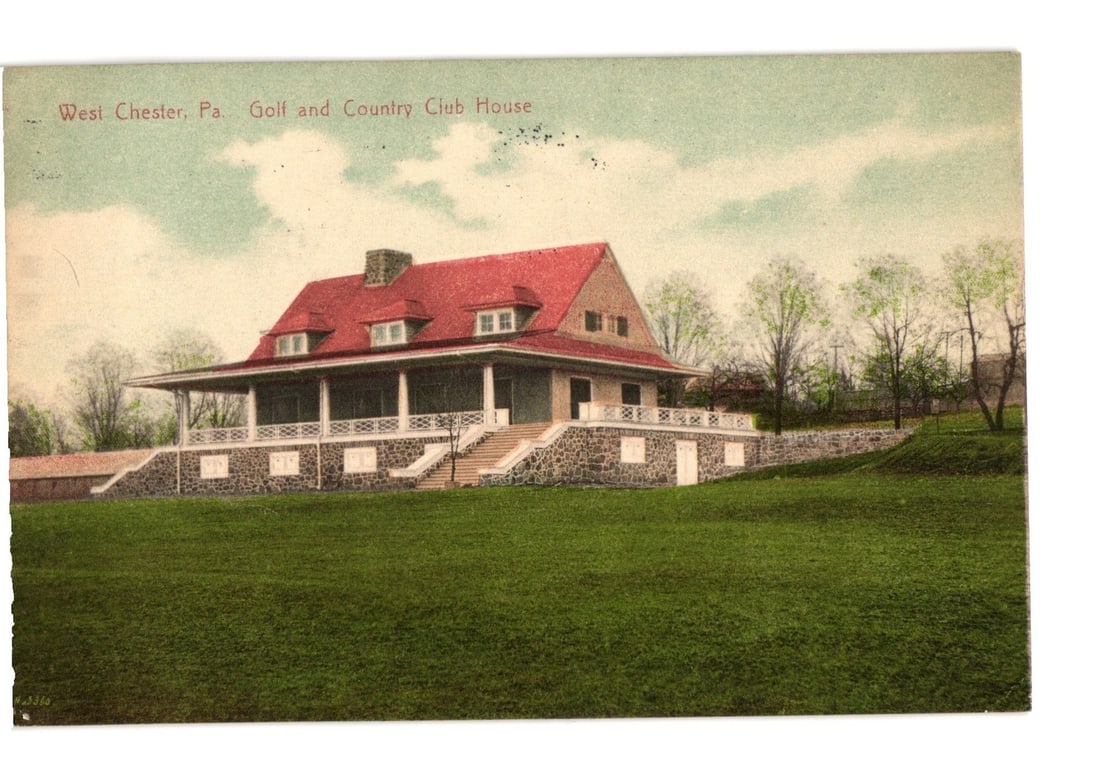 West Chester, Pennsylvania Golf and Country Club House postcard, early 20th-century view.: A large, two-story clubhouse building with a prominent red gabled roof and multiple dormer windows. A wide, wrap-around porch supported by white columns extends across the front and sides. The buildin