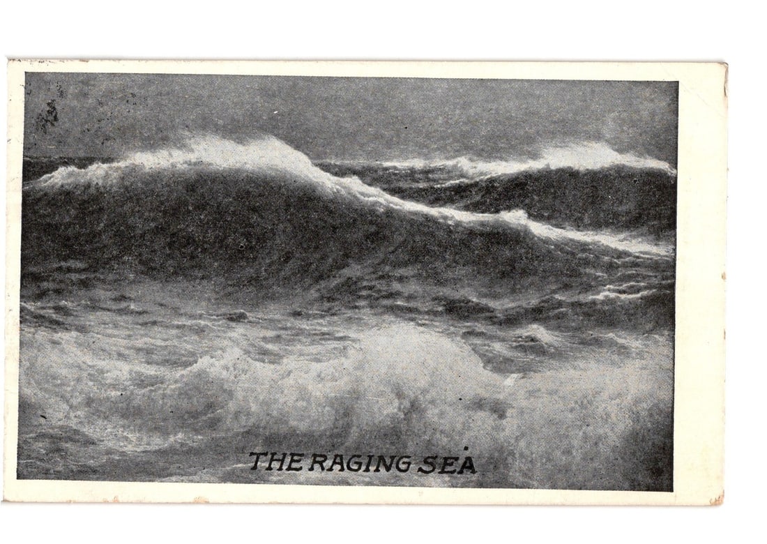 Early 20th Century Postcard: 'The Raging Sea' - Powerful Ocean Waves Breaking.: A dramatic black and white image features powerful ocean waves breaking with significant white foam and spray. The turbulent sea fills the frame, with the horizon line visible towards the top. A dynam