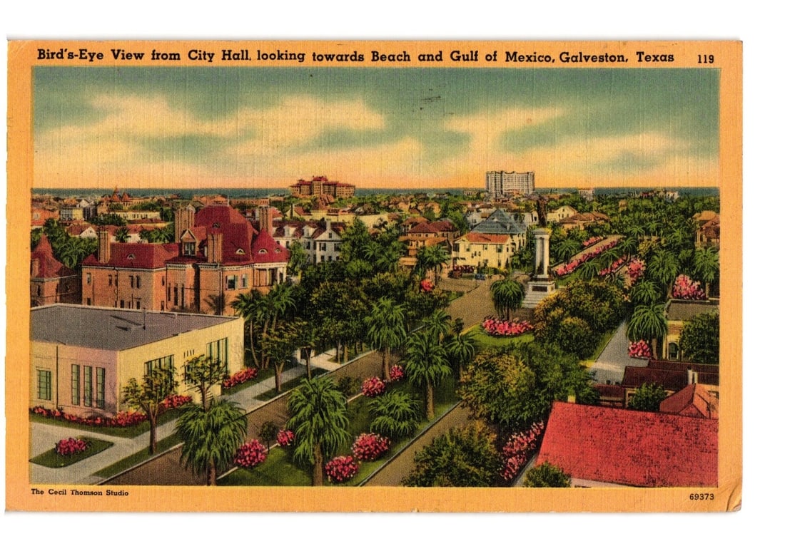 Bird's-Eye View of Galveston, Texas Cityscape, Beach, and Gulf of Mexico, 1941 Postcard: A bird's-eye view of Galveston, Texas, presents a cityscape extending towards the beach and the Gulf of Mexico. The foreground features various buildings, including a prominent light-colored structure