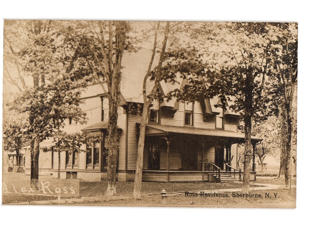 Historic Sepia Real Photo Postcard: Ross Residence, Sherburne, New York, Early 20th Century.: A multi-story residential building, identified as the Ross Residence, stands prominently, framed by several mature deciduous trees. The architecture features shingle siding, multiple gables with decor