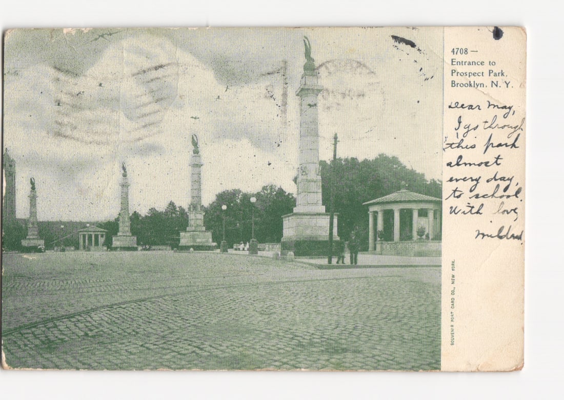 Early 20th Century Chromolithograph Postcard of Prospect Park Entrance, Brooklyn, New York: A wide view of the entrance to Prospect Park in Brooklyn, New York. The scene features a large, paved plaza with several tall, classical-style monuments, each topped with a winged statue. To the right