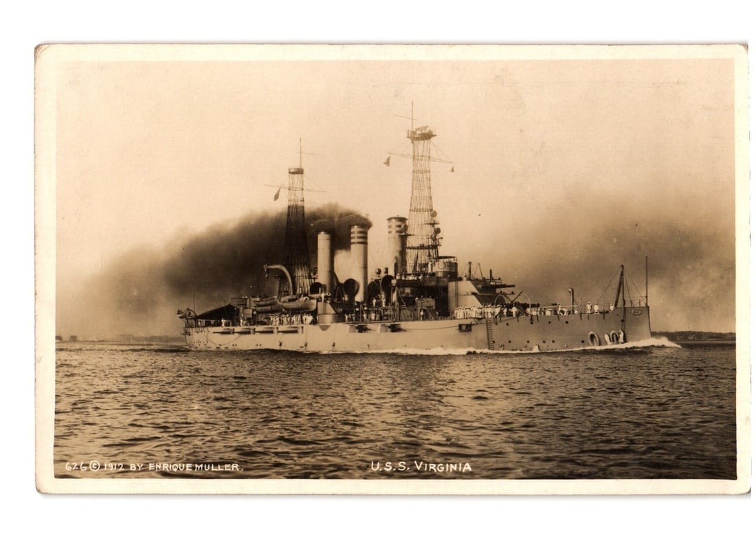 Battleship U.S.S. Virginia Steaming on Water, 1912 Photography Postcard by Enrique Muller: A sepia-toned photographic image depicts the battleship U.S.S. Virginia underway, viewed from the starboard side. The vessel is prominently centered, moving through water that shows a wake at its bow 