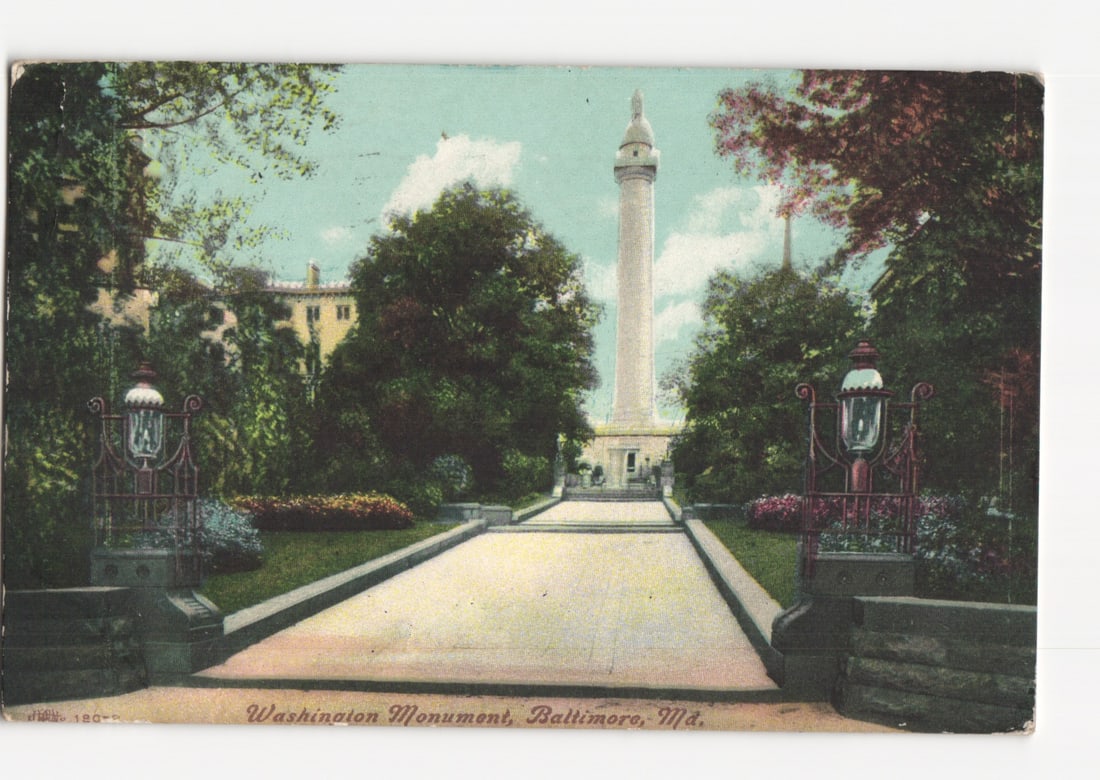 Washington Monument, Baltimore, Maryland, ornate lamps and lush gardens, early 20th C postcard: A view of the Washington Monument in Baltimore, Maryland, depicted as a tall, white column topped with a statue, rising prominently at the end of a long, paved path. The path is flanked by manicured l