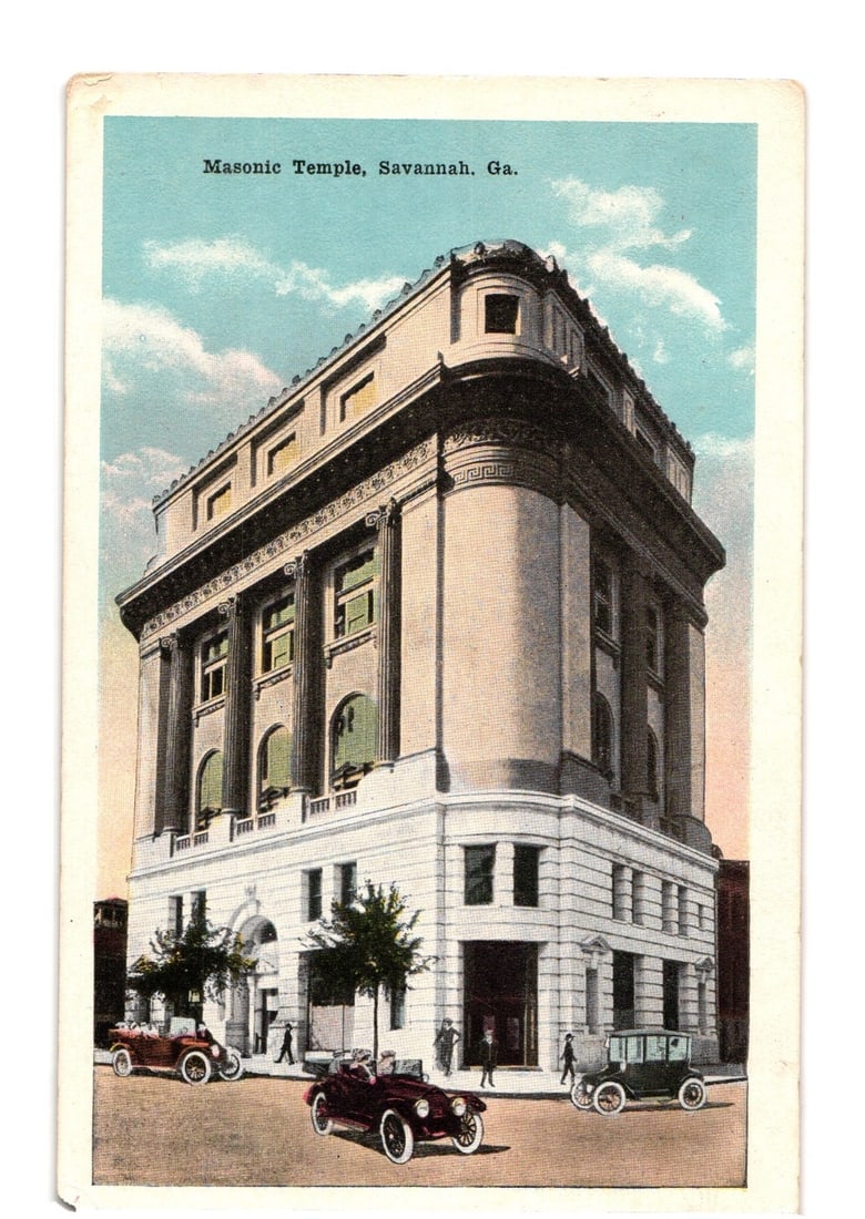 Vintage postcard featuring the Masonic Temple in Savannah, Georgia, with early automobiles.: The Masonic Temple in Savannah, Georgia, is depicted in a three-quarter view, filling much of the frame. The multi-story building exhibits classical architectural elements, including prominent columns