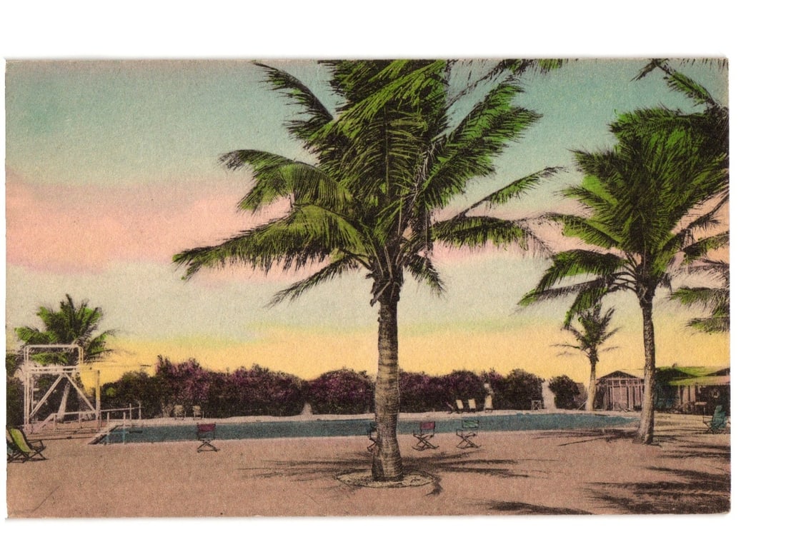 Handcolored postcard of Swimming Pool at The Cabanas, Boca Raton, Florida, with palm trees.: A handcolored view of a swimming pool at The Cabanas in Boca Raton, Florida. Several tall palm trees dominate the foreground and mid-ground, casting shadows on the paved area surrounding the pool. Gre