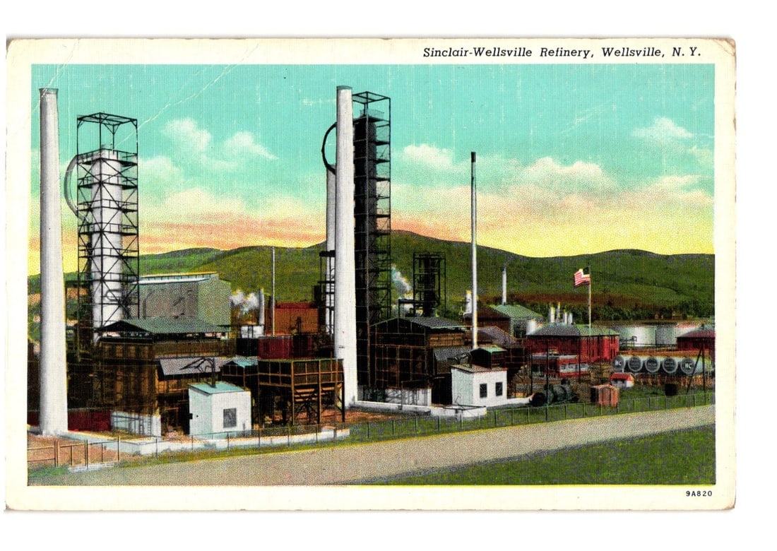 Sinclair-Wellsville Refinery, Wellsville, N. Y., Mid-20th Century Industrial Postcard: A wide view of the Sinclair-Wellsville Refinery in Wellsville, New York. The scene is dominated by tall industrial structures, including multiple cracking towers, smokestacks, and various interconnect