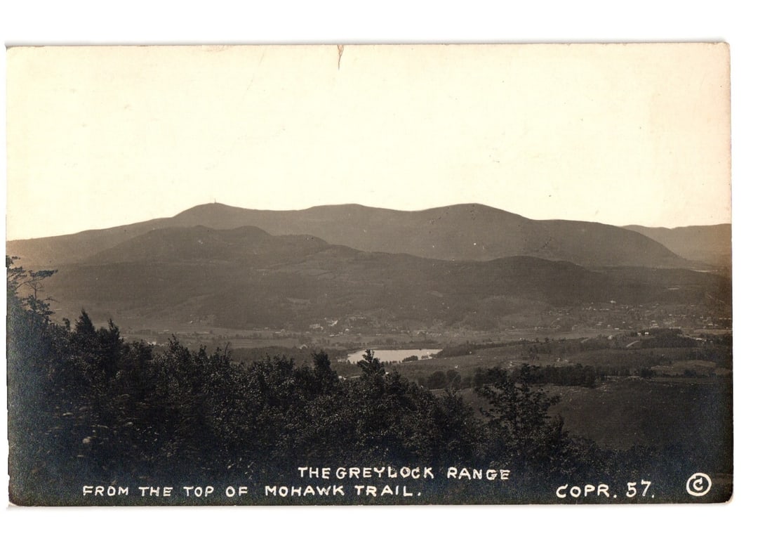Black and white postcard showing The Greylock Range from the Mohawk Trail, Massachusetts, early 20th: Panoramic black and white Real Photo Postcard (RPPC) of The Greylock Range, viewed from the Mohawk Trail. The landscape features multiple mountain ridges receding into the distance under a vast sky. D