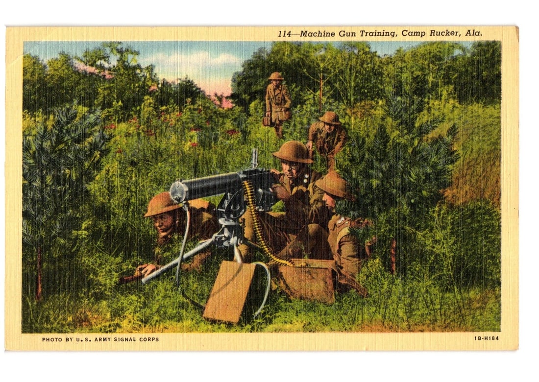 Soldiers training with a machine gun at Camp Rucker, Alabama, early-mid 20th century postcard.: A group of U.S. Army soldiers in military fatigues and helmets are depicted in a field during machine gun training. Three soldiers are positioned around a heavy machine gun, with one prone, one kneeli