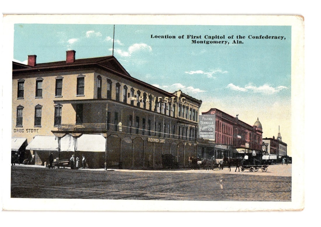 Historic Street Scene Postcard: First Capitol of the Confederacy, Montgomery, Ala.: A street scene depicting a row of multi-story commercial buildings under a partly cloudy sky. The foreground shows a dirt or unpaved street with trolley tracks. Several horse-drawn carriages and a few