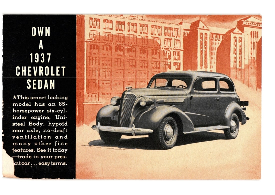 1937 Chevrolet Sedan Promotional Postcard showcasing Car in front of Industrial Buildings: A 1937 Chevrolet Sedan is depicted in a three-quarter view, angled towards the left, positioned on a light-colored ground. The vehicle features a rounded body style, prominent grille, and two visible 