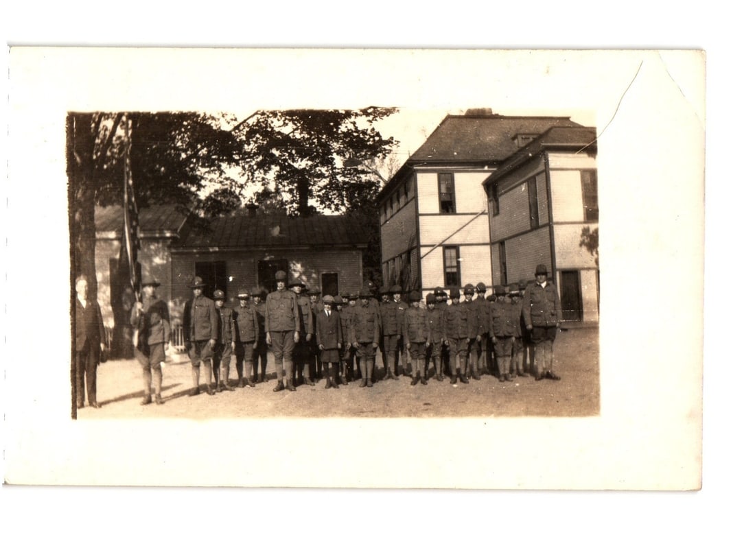 Early 20th Century Real Photo Postcard depicting a uniformed military group outside buildings. (1 of 2)