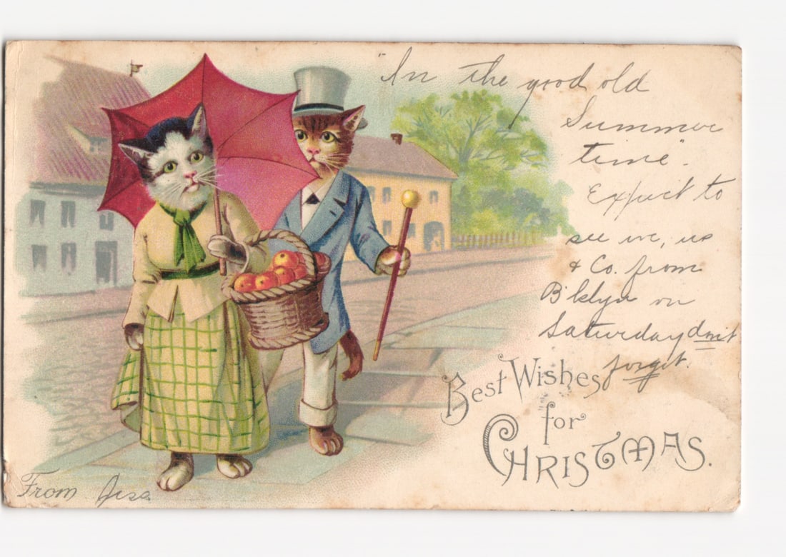 Illustrated Anthropomorphic Cats with Umbrella and Basket, Christmas Greetings Postcard: An illustrated chromolithograph postcard depicting two anthropomorphic cats walking on a paved street. The cat on the left wears a green plaid skirt and a green top, holding an open red umbrella over 