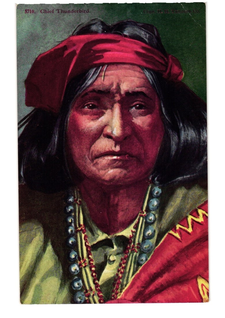 Chromolithograph postcard portraying Chief Thunderbird, a Navajo Indigenous man, early 20th century.: A portrait of Chief Thunderbird, an Indigenous man, depicted in a close-up, head and shoulders view. He wears a red bandana around his forehead and has dark hair. Multiple strands of beaded necklaces,