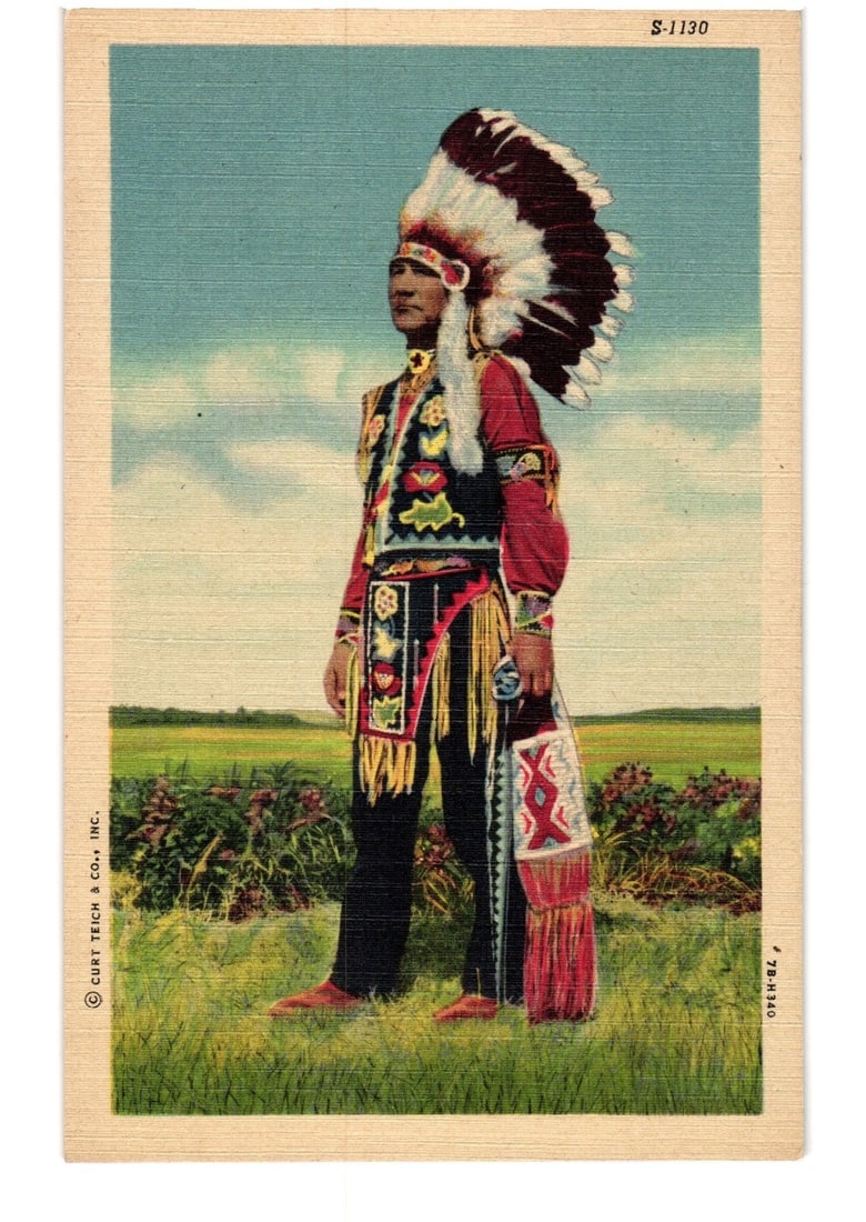 Indigenous Man in Full Feathered Headdress and Traditional Regalia, Mid-20th Century Postcard: A full-length portrait of a man, depicted as indigenous, standing in elaborate traditional regalia. He wears a large feathered headdress, a red long-sleeved shirt, an intricately embroidered vest with
