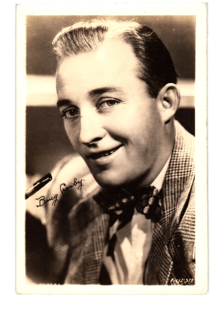 Portrait postcard of American singer and actor Bing Crosby, smiling, in checked jacket, 1930s era. (1 of 2)