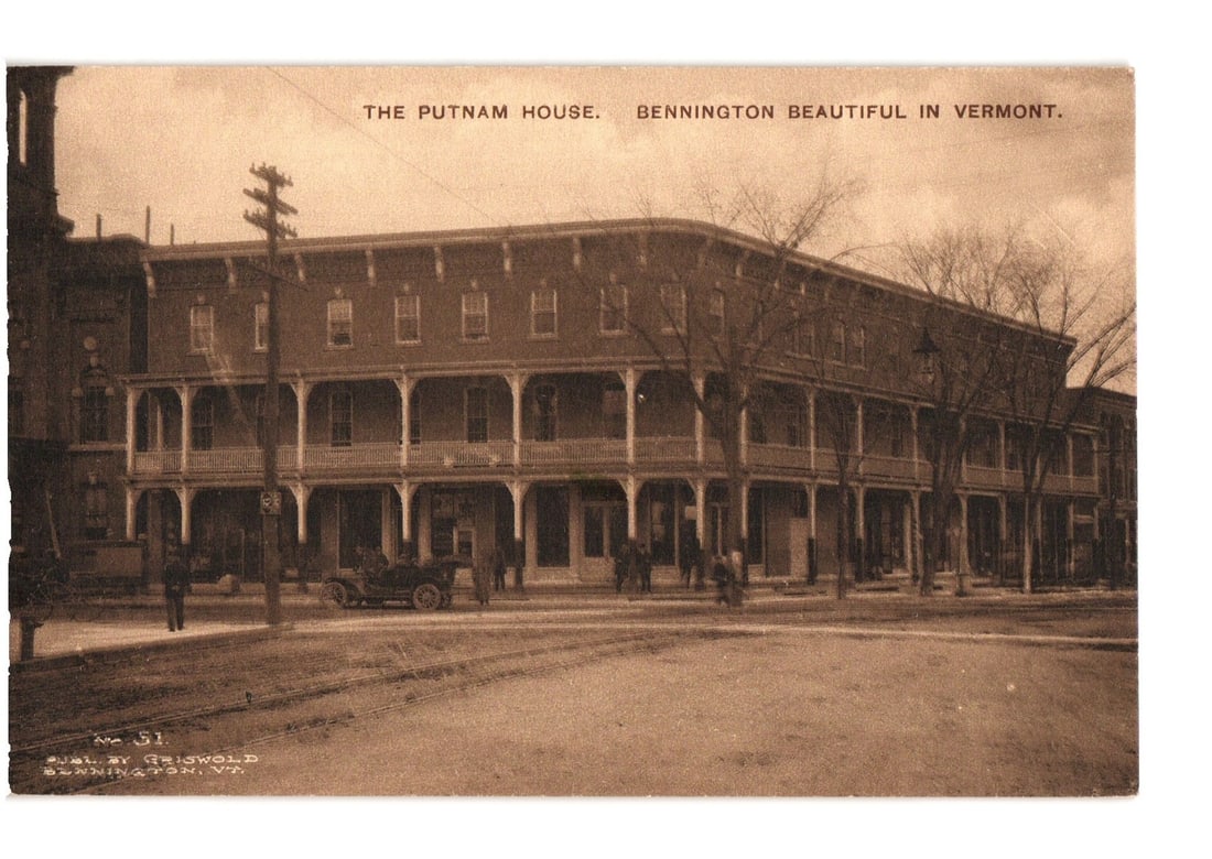 The Putnam House Hotel, Bennington, Vermont, early 20th Century street scene postcard: A sepia-toned photographic print features The Putnam House, a large, multi-story building in Bennington, Vermont, with a two-story wrap-around porch. Leafless trees, an early 20th-century automobile, 