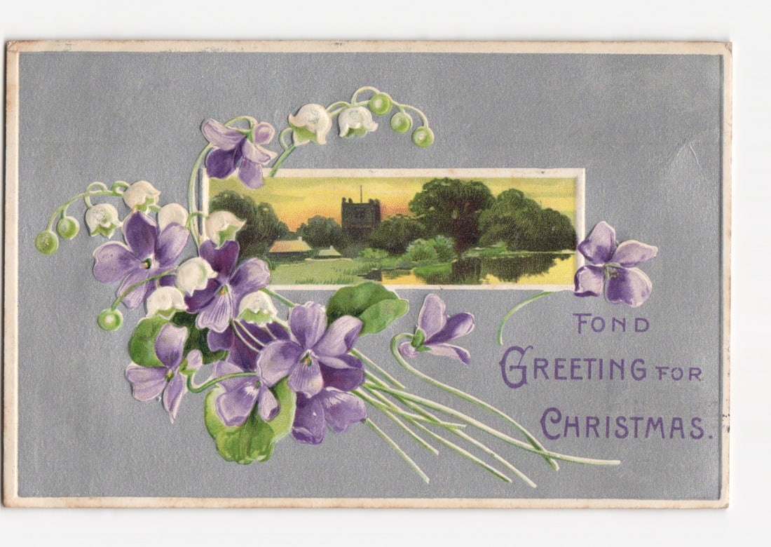 Christmas Greeting Postcard with Violets, Lily-of-the-Valley, and a Scenic Church Landscape: A vibrant chromolithograph depicts a large bouquet of purple violets and white lily-of-the-valley blossoms with green foliage, positioned on the left and bottom center against a textured grey-blue bac