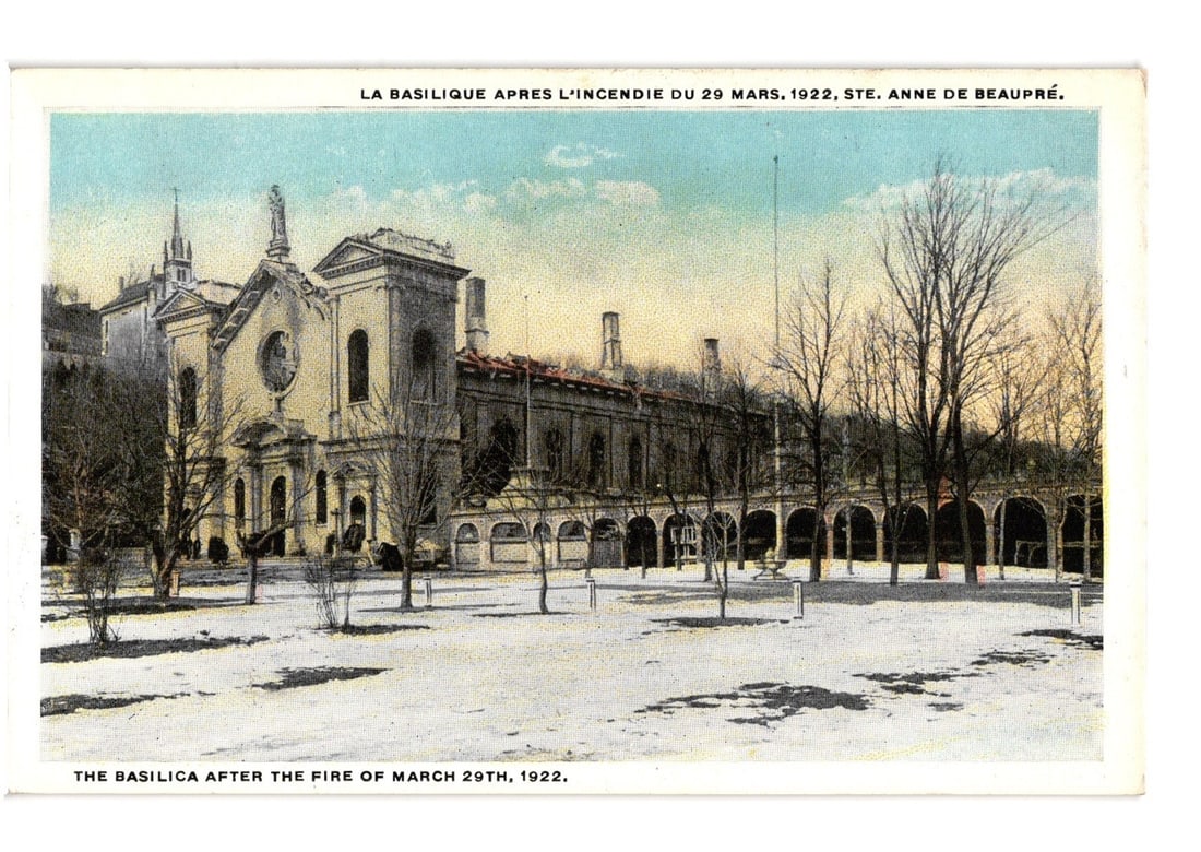 Color Lithograph Postcard Depicting Sainte Anne de Beaupre Basilica After March 1922 Fire: The Basilica of Sainte Anne de Beaupre is depicted after the fire of March 29, 1922, with visible damage to its structure, particularly the roofline. Snow covers the ground in the foreground and aroun