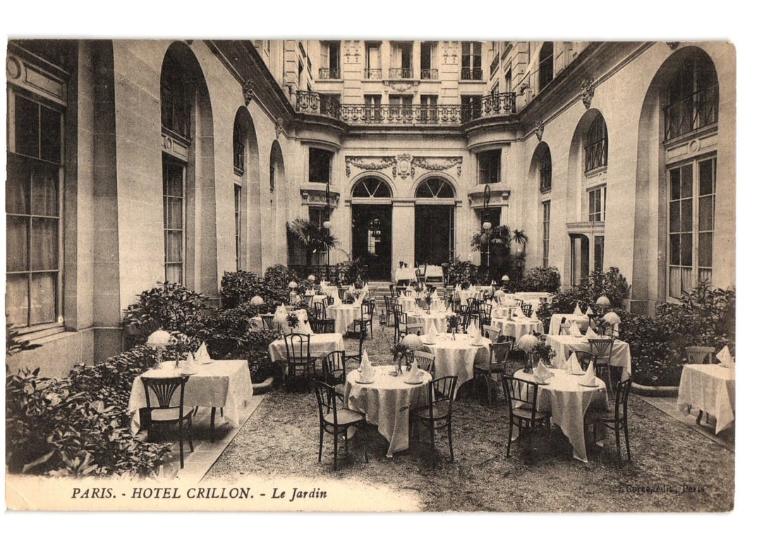 Historic Hotel Crillon Courtyard Garden Dining Scene in Paris, France, Early 20th Century Postcard: A wide-angle photographic print captures the formal courtyard garden of the Hotel Crillon. The scene features numerous white-clothed dining tables, each set with chairs, arranged on a gravel or dirt s
