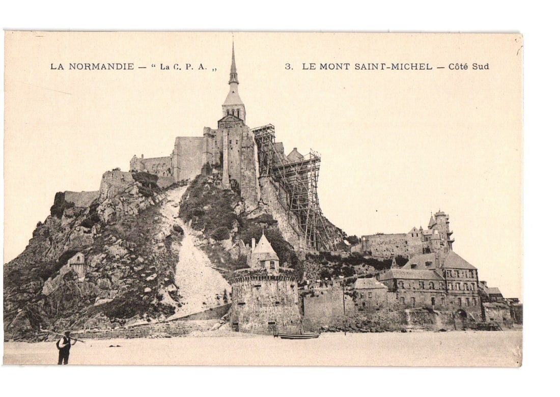 Mont Saint-Michel, Normandy, France, South Coast View with Scaffolding, Photographic Postcard: A photographic postcard depicts Mont Saint-Michel, a fortified island commune in Normandy, France, viewed from its south coast. The imposing abbey complex crowns a rocky island, with its prominent spi