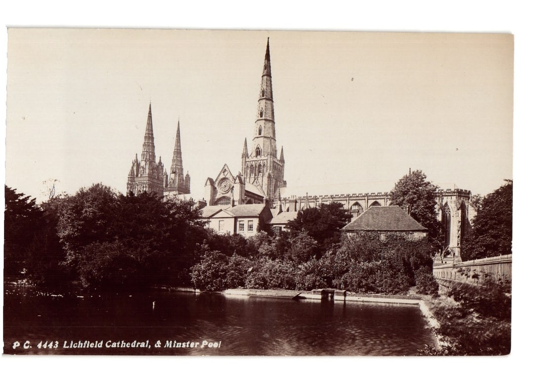 Sepia photographic postcard showing Lichfield Cathedral and Minster Pool, early 20th century: Lichfield Cathedral with its three prominent spires dominates the mid-ground, viewed across Minster Pool. Lush trees and foliage line the edges of the pool and partially obscure the lower sections of 