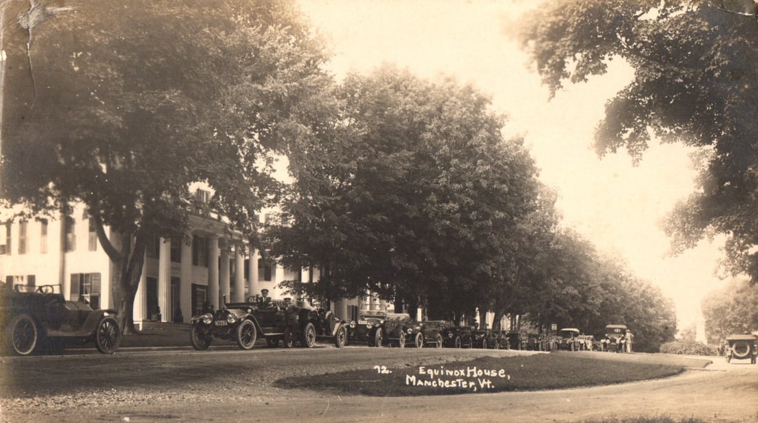 Vintage Automobiles at Equinox House, Manchester, Vermont Roadside Postcard, circa 1910s: A long line of early 20th-century automobiles parked along a broad tree-lined road, leading up to the Equinox House. The large, classical Revival-style building features a prominent colonnade. Several