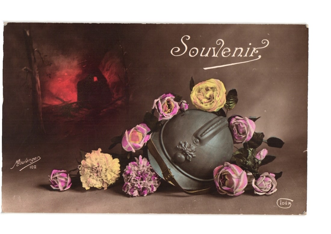 Hand-colored French WWI Adrian Helmet, Flowers, and Battlefield Scene Souvenir postcard: A hand-colored photograph features a French World War I Adrian helmet adorned with various flowers, set against a dark, dramatic background. The helmet is positioned in the foreground, slightly right 