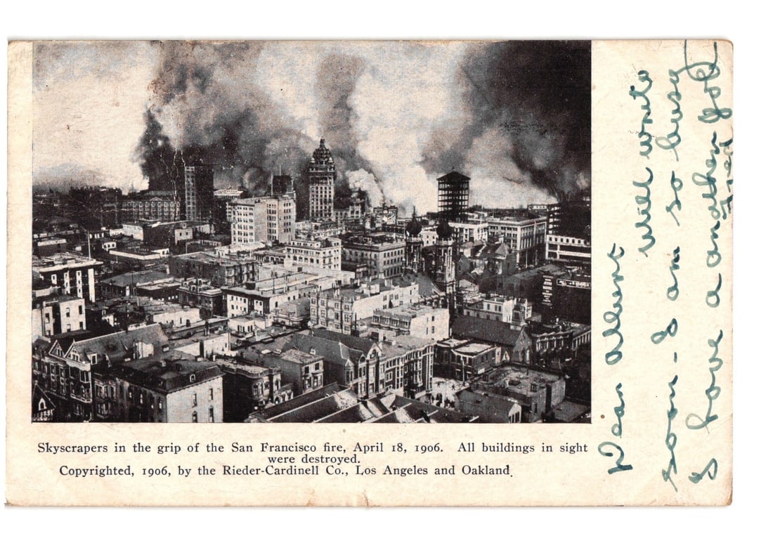 San Francisco Fire of April 18, 1906: Sky-scrapers in Grip of Fire - Cityscape Postcard: An elevated cityscape view depicting widespread destruction from a large fire. Numerous multi-story buildings are visible, many engulfed in smoke plumes, indicating active burning or recent damage. Th