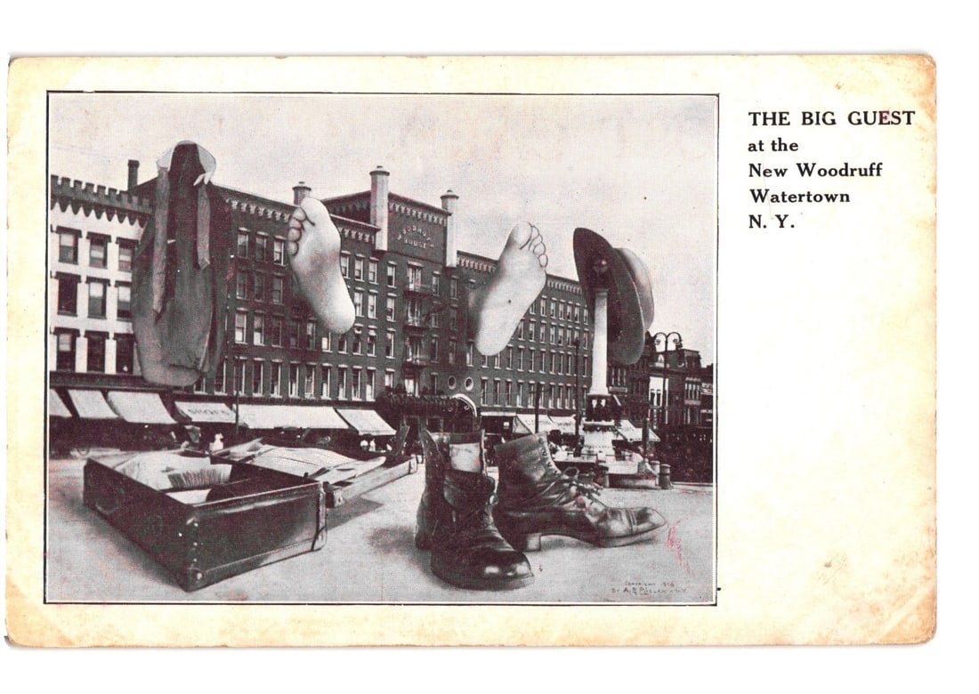 Giant's Shoes and Feet on Street Scene, New Woodruff Hotel, Watertown, N.Y. postcard: A surreal photographic image depicts oversized footwear, bare feet, a hat, and an open suitcase superimposed onto a street scene. The large items are positioned in the foreground, creating the illusio