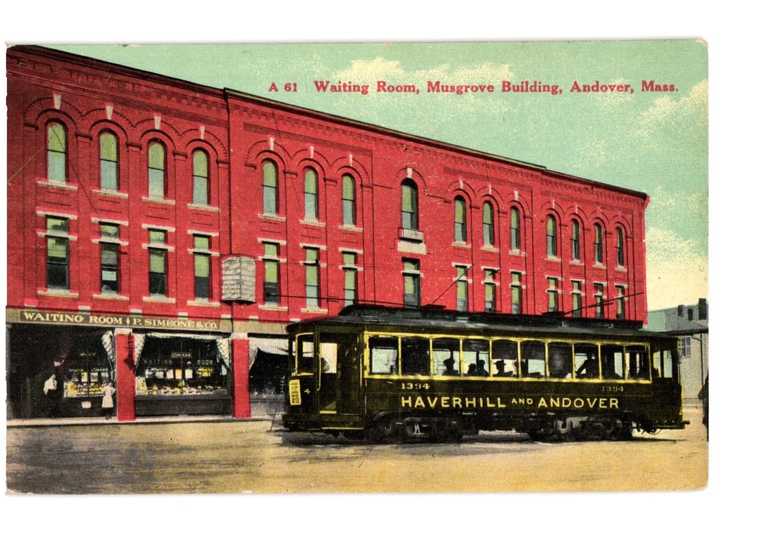 Andover, Massachusetts: Musgrove Building Waiting Room & Streetcar View Postcard: A red brick building featuring multiple arched windows and a storefront with signage reading 'WAITING ROOM' and 'P. SIMEONE & CO.' dominates the left side of the frame. An electric streetcar with over