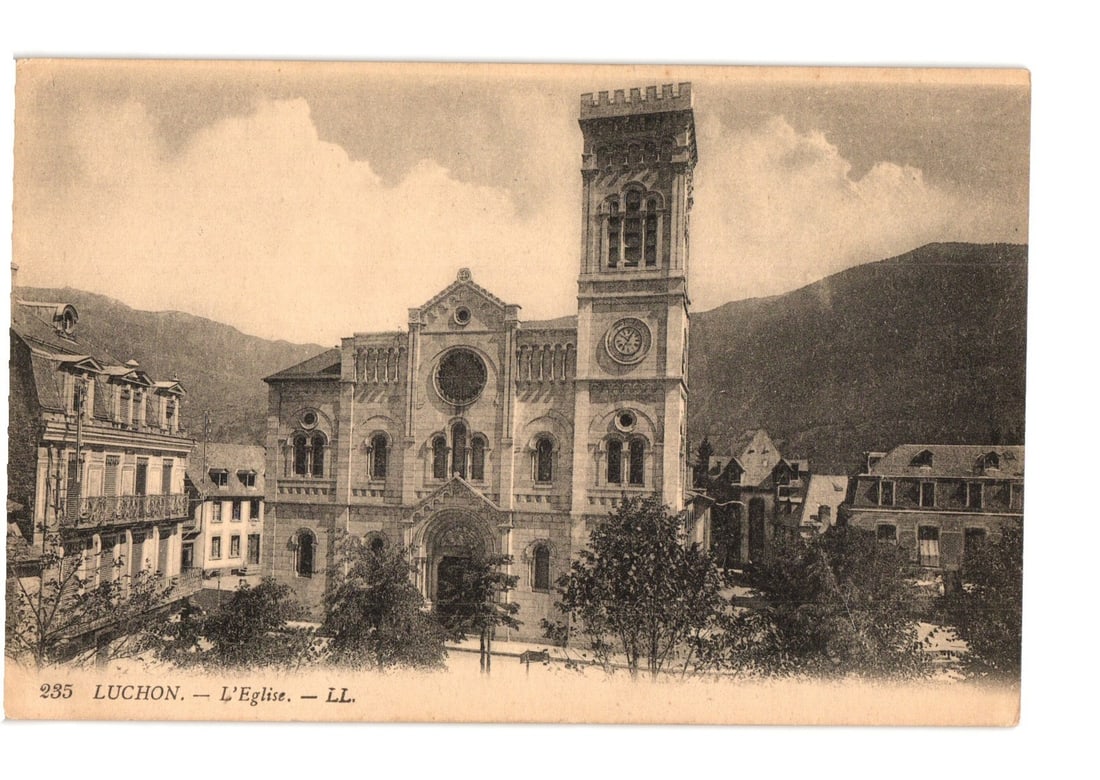 Vintage sepia postcard of The Church in Luchon, France, with grand architecture and mountains.: A large, ornate church with a tall, square bell tower featuring a clock face dominates the center of the image. The church facade displays multiple arched windows, columns, and intricate stone carving
