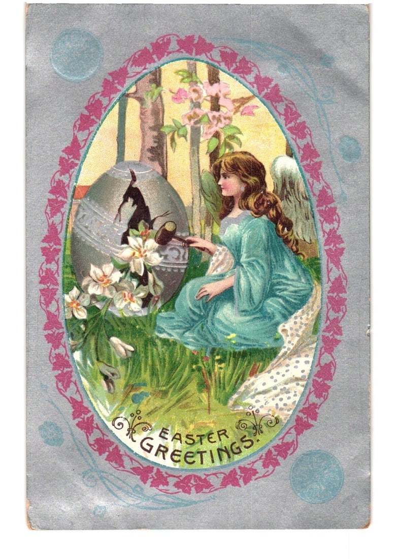 1908 Chromolithograph Postcard: Angelic Figure Tapping a Cracked Easter Egg with Spring Flowers: A young woman with flowing brown hair, wearing a light blue gown, is depicted seated in a grassy field. She possesses visible angel wings on her right side. She holds a small hammer, using it to tap a